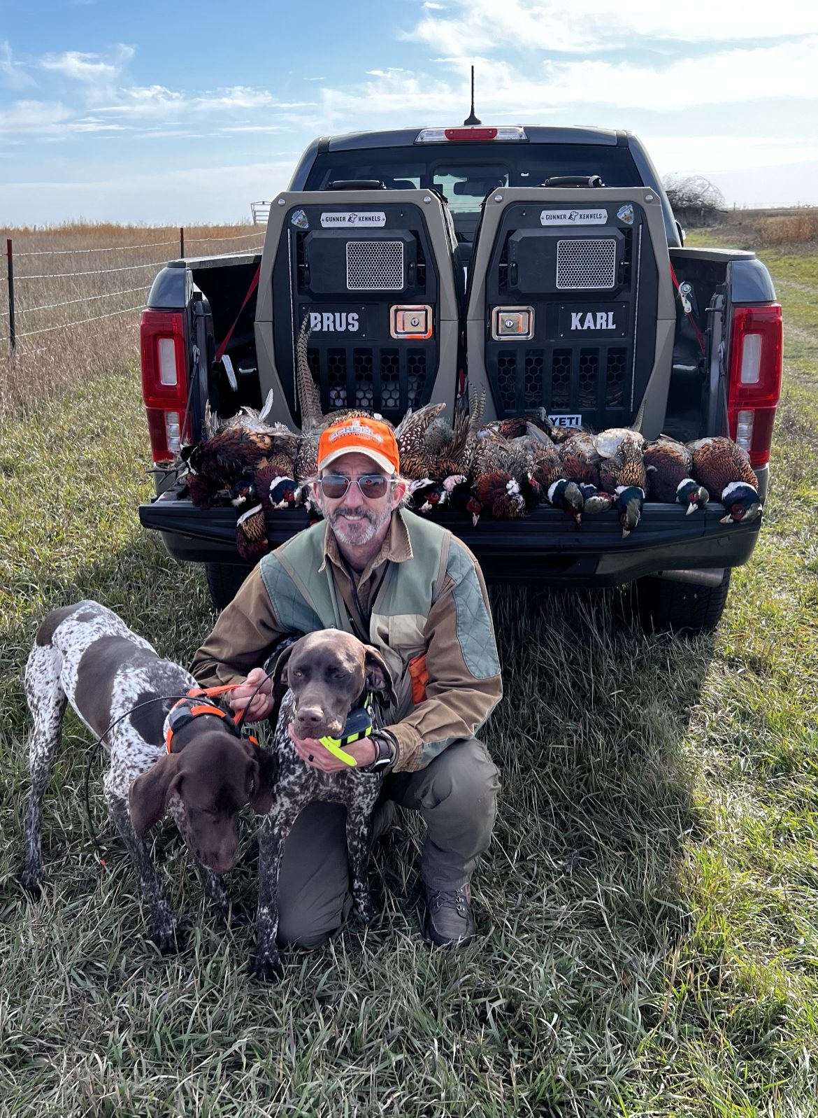 Karl and Brus with harvested roosters; kennels labeled BRUS and KARL